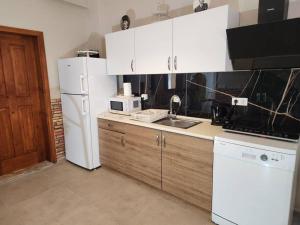 a kitchen with a white refrigerator and a sink at Traumhaus mitten in der City 60 Meter zum Meer in Kuşadası