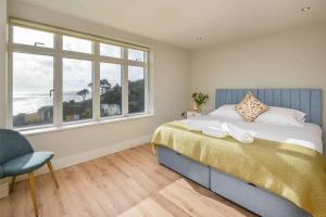 a bedroom with a large bed and a window at Crow's Nest, Polperro in Polperro