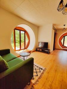 a living room with a couch and a circular window at Casa Florestal - Fatela - Hobbit House , Cabins in Fatela