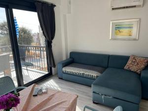 a living room with a blue couch and a balcony at Ozy Apart / Can Andifli in Kaş