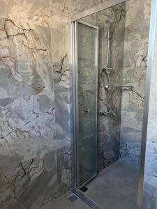 a shower with a glass door in a bathroom at Ozy Apart / Can Andifli in Kaş
