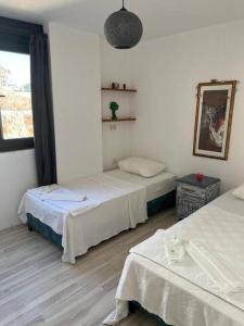 a room with two beds and a window at Ozy Apart / Can Andifli in Kas
