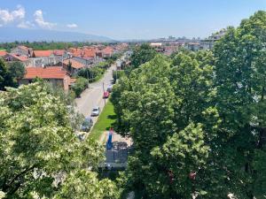 eine von Bäumen gesäumte Straße in einer Stadt mit Häusern in der Unterkunft Sunrise Apartment in Skopje