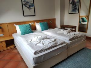DewichowにあるFerienwohnung Wasserblick mit Balkonのベッドルーム1室(白いシーツと青い枕のベッド2台付)