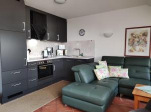 a living room with a couch and a kitchen at Ferienwohnung Wasserblick mit Balkon in Dewichow