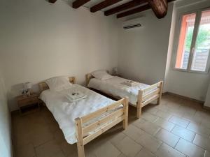sypialnia z dwoma łóżkami i oknem w obiekcie Gîte tout confort en Cévennes 3 étoiles w mieście Saint-Martin-de-Valgalgues