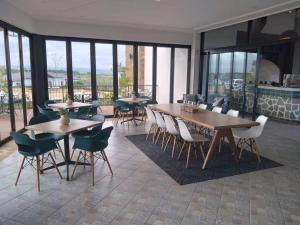 a dining room with tables and chairs and windows at Ballito Hills Lifestyle 1 Bed in Ballito