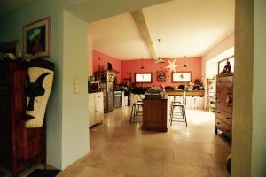 Mas en drôme provençale في Montjoux: مطبخ بجدران وردية وطاولة وكراسي
