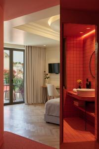 アテネにあるDWELL - Elegant City Stayのベッドとバスルーム付きのホテルルームです。