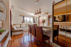 a kitchen and living room with a table and chairs at Suítes Jurerê Internacional in Florianópolis