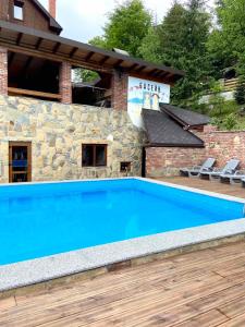 a large blue swimming pool in front of a building at Shovkova Kositsya in Yaremche