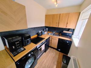 a small kitchen with a washer and dryer in it at Castle View Guest House in Harlech