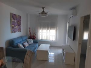 een woonkamer met een blauwe bank en een tafel bij RondaIVdeluxe in Fuengirola