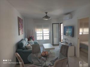 een woonkamer met een blauwe bank en een glazen tafel bij RondaIVdeluxe in Fuengirola
