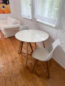 een witte tafel en een stoel in een kamer bij Mühlenhaus Herkenrath in Bergisch Gladbach