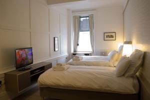 a hotel room with two beds and a television at Grasshopper Hotel Glasgow in Glasgow