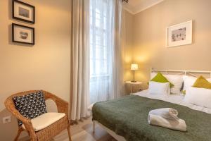 um quarto com uma cama, uma cadeira e uma janela em ORANGEHOMES One Bedroom Comfy Apartment em Budapeste