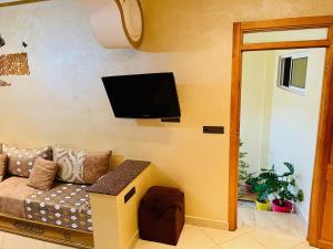 sala de estar con sofá y TV en la pared en الحسيمة, en Alhucemas