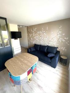 uma sala de estar com um sofá e uma mesa em Studio à 50m à pieds de la plage em Neufchâtel-Hardelot