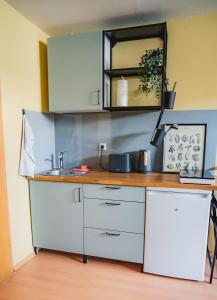 una cocina con armarios blancos y fregadero en Gin&Tonic, en Stralsund