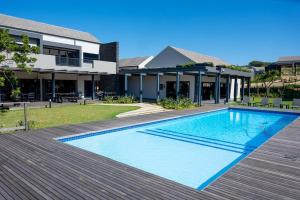 a swimming pool in front of a house at Gorgeous Ballito One Bedroom apartment in Ballito