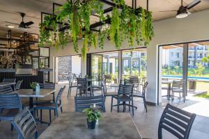 a restaurant with tables and chairs and plants at Gorgeous Ballito One Bedroom apartment in Ballito