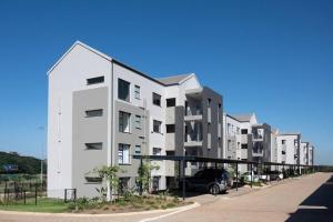 a row of white apartment buildings on a street at Gorgeous Ballito One Bedroom apartment in Ballito