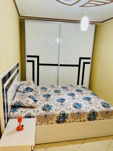 1 dormitorio con 1 cama y 1 mesa en الحسيمة, en Alhucemas