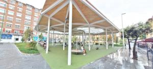 a pavilion with people sitting on benches in a park at COSY Apartment AREETA STATION las Arenas Getxo in Getxo