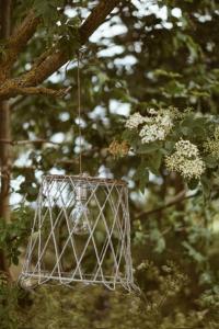 a white bird feeder hanging from a tree at Axatorpsgården in Trelleborg