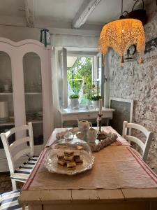 Robinson house Leticia في Čunski: طاولة غرفة الطعام مع طبق من الطعام عليها