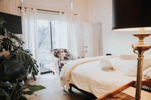 a bedroom with a bed and a chair and a window at Hau Lodge Malalcahuello Corralco Starlink in Malalcahuello