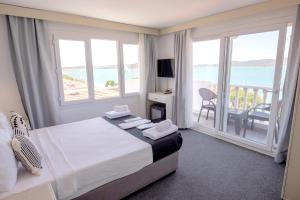 a bedroom with a bed with a view of the ocean at Çamlık 87 Hotel Ayvalık in Ayvalık