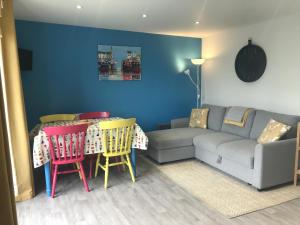 sala de estar con sofá, mesa y sillas en Kingfisher Glamping Cabin, en Bodmin