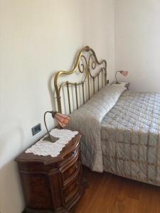 een slaapkamer met een bed en een dressoir met een nachtkastje ernaast bij Casa ivana in Borghetto di Vara