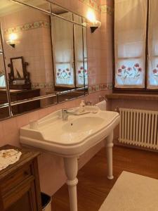 een badkamer met een witte wastafel en een spiegel bij Casa ivana in Borghetto di Vara