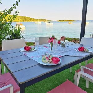 a blue table with roses on it with a view of the water at 5D in Murter +25 photos