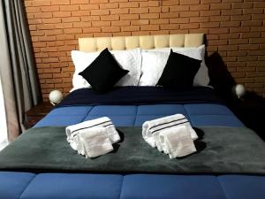 uma cama azul com almofadas pretas e brancas em Casa de vidro em Campos do Jordão
