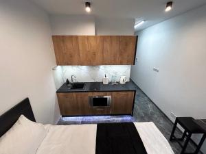 una piccola cucina con lavandino e un letto in una camera di 33 Modern Warsaw Apartments a Varsavia