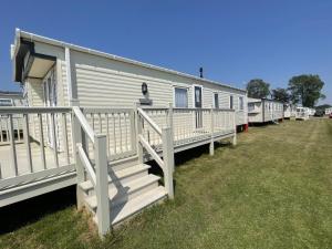 a row of mobile homes parked on the grass at Stunning 3-Bed Caravan in Clacton-on-Sea in Clacton-on-Sea