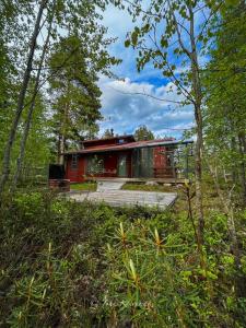 a red and green house in the middle of a forest at Loma-asunto Kaarna, Kalajärvi in Peräseinäjoki