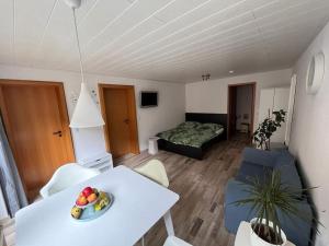 a living room with a white table and a bed at Weserbutze in Bodenwerder