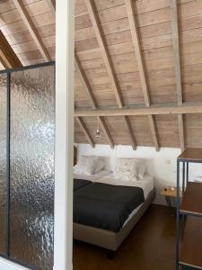 Ce lit se trouve dans un dortoir doté d'un plafond en bois. dans l'établissement Maracci vakantiehoeve, à Pervijze