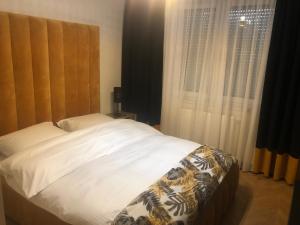 a bedroom with a bed and a window with curtains at Solankowa Aleja Apartament Rodzinny in Inowrocław