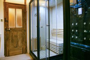 una stanza con una porta e una stanza con vetro di La Maison du Bonheur & Spa 