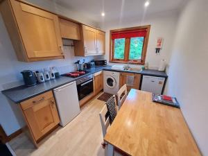 cocina con mesa de madera y encimera en Kings Reach - Dunadd Cottage en Kilmichael Glassary