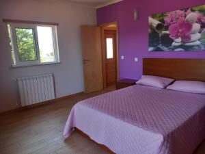 - une chambre avec un lit et un mur violet dans l'établissement Casa da Bela Vista, à Braga