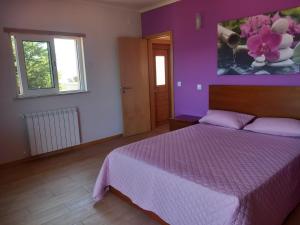 Un dormitorio con una cama y una pared morada. en Casa da Bela Vista, en Braga