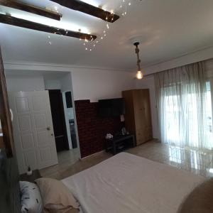 a bedroom with a bed and a flat screen tv at Studio near the port !!! in Paralia Katerinis