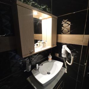 een badkamer met een wastafel, een spiegel en een telefoon bij Studio near the port !!! in Paralia Katerinis